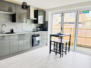 een keuken met 2 barkrukken en een aanrecht bij Stylish Cambridge Apartment with Garden in Cambridge +26 foto's