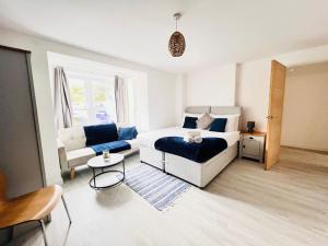 een slaapkamer met een bed, een bank en een tafel bij Stylish Cambridge Apartment with Garden in Cambridge