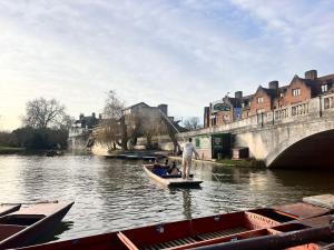 een man roeit een boot op een rivier bij Stylish Cambridge Apartment with Garden in Cambridge