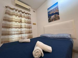 una camera da letto con un letto blu e asciugamani di Seaview Serenity 3-Bedroom Apt view over Valletta Harbour a Sliema