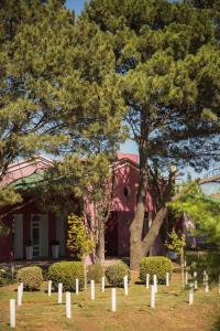 a group of trees in front of a red building at La Posta Hotel de Campo in Tres Lomas