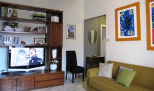 een woonkamer met een televisie op een houten entertainmentcentrum bij La Casa sul Corso in Leonforte