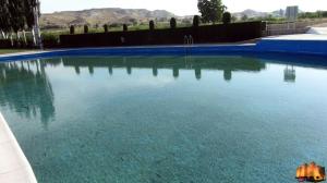 a large pool of blue water in a yard at El rincón coqueto de fina in Orce