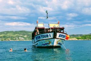 Lua de Aquarius Boutique Hostel في Tamoios: مجموعة من الناس يسبحون في الماء بجانب قارب