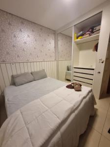 una camera da letto con un letto bianco e un orsacchiotto sopra di Quarto em casa com lazer completo a Indaiatuba