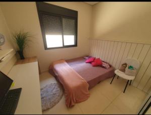 a bedroom with a bed and a window and a laptop at Quarto em casa com lazer completo in Indaiatuba