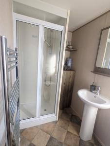 y baño con ducha y lavamanos. en Caravan sleeps 8 at Littlesea, Weymouth en Wyke Regis