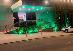 een gebouw met groene lichten op de stoep bij Pousada Tropical in Barra do Garças