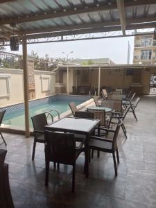 a patio with tables and chairs next to a swimming pool at Immaculate Diamond Hotel & Apartments in Abuja