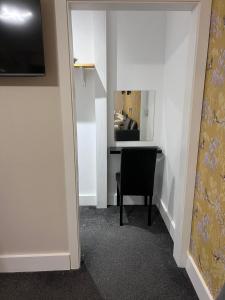um quarto com uma secretária com uma cadeira e um espelho em Woolaway 2 em Taunton