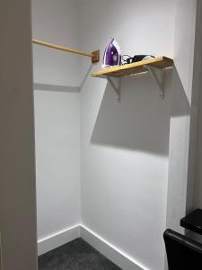 a room with a white wall with a wooden shelf at Woolaway 2 in Taunton