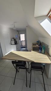 a large wooden table in a kitchen with two chairs at L'appart le “BapTho” in Cléder