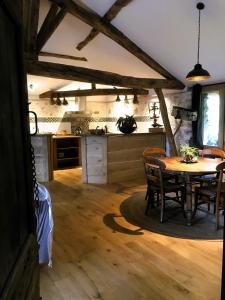 eine Küche und ein Esszimmer mit einem Tisch und Stühlen in der Unterkunft ASPET Ancienne étable in Aspet