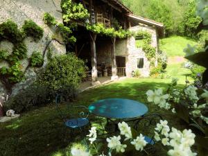 a table and chairs in the yard of a house at ASPET Ancienne étable in Aspet