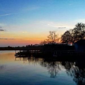 a sunset over a body of water with a dock at Het Bruggetje Leekstermeer in Matsloot