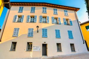 a building with blue shutters on it at residenza luxury in pieno centro storico in Iseo