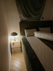 um quarto com uma cama e um candeeiro sobre uma mesa em Bielsko Happy Apartment em Bielsko-Biala