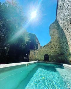 a swimming pool with the sun in the sky at La Vieille Demeure in Torreilles
