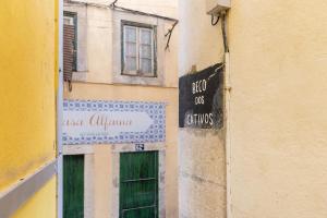 um sinal na lateral de um edifício com uma porta verde em Apartamento em Alfama - Centro Histórico em Lisboa