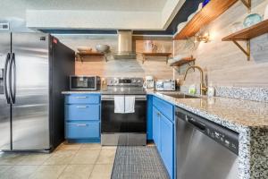 uma cozinha com armários azuis e um frigorífico de aço inoxidável em The Beach Is Back em Myrtle Beach