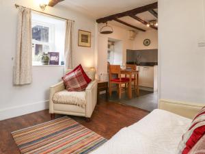een woonkamer met een bank, een stoel en een tafel bij Buttercup Cottage in Troutbeck
