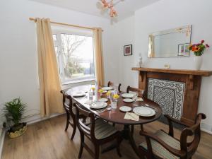 a dining room with a table and chairs and a window at Cooper Cottage in Neyland