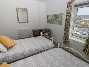 1 dormitorio con cama y ventana en Cooper Cottage en Neyland