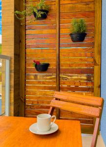 - une table avec une tasse de café et un banc dans l'établissement Residencial Mãe terra, à Bombinhas