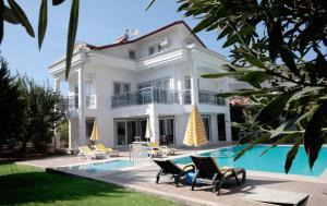 a white house with a pool in front of it at Villa Raya3 in Fethiye