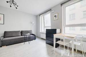 a living room with a couch and a table at Narutowicza I by LookAp in Łódź