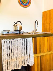 a kitchen counter with a sink and a pot on it at Residencial Mãe terra in Bombinhas