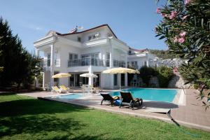 a large white house with a swimming pool at Villa Raya3 in Fethiye