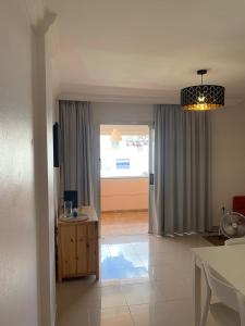 sala de estar con ventana grande y lámpara de araña en Los Cristianos Apartamento en residencial Los Seres, en Los Cristianos