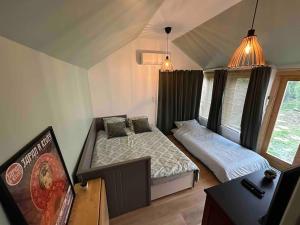 a bedroom with two beds and a tv in it at Japan House : studio en bois Zen - Wifi - Parking gratuit in Angoulême