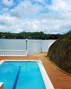 a swimming pool next to a body of water at Casa Isla en la Represa de Prado in Prado