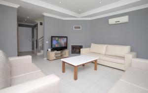 a living room with white furniture and a tv at Villa Raya3 in Fethiye