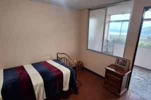 1 dormitorio con cama y ventana en Casa y mirador, en Otavalo