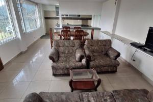 sala de estar con sofá, mesa y sillas en Casa y mirador, en Otavalo