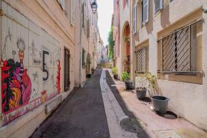 un callejón con graffiti al lado de los edificios en Charmant T2 au cœur du Panier, en Marsella