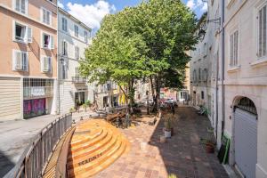 een bankje in het midden van een straat met gebouwen bij Charmant T2 au cœur du Panier in Marseille