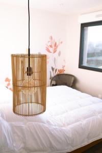 a chandelier hanging over a bed in a bedroom at ENTRE TERRE ET MER in Desvres