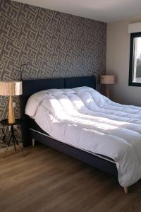 a large bed in a bedroom with two lamps at ENTRE TERRE ET MER in Desvres