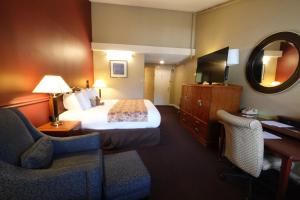 a hotel room with a bed and a mirror at Fireside Inn & Suites West Lebanon in West Lebanon