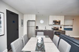 uma cozinha e sala de jantar com mesa e cadeiras em Clifton Hill Hideaway 4A - Two Bedroom Condo em Cataratas do Niágara