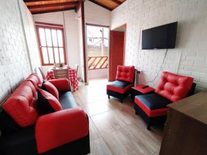 Hermoso apartamento en Curití في كوريتي: غرفة معيشة بأثاث احمر وتلفزيون بشاشة مسطحة