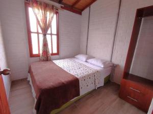 a small bedroom with a bed and a window at Hermoso apartamento en Curití in Curití