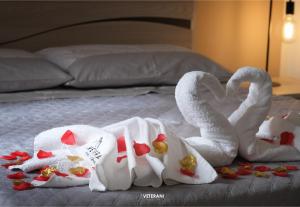 two swans towels on a bed with hearts at Veterani Holidays Cefalù in Cefalù