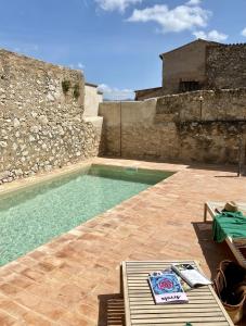 a swimming pool with a table and a building at Casa Rural Boutique Ca Bolo in Pinell de Bray