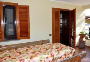 a bedroom with a large bed with a floral bedspread at Appartamenti Pian d'Alma in Punta Ala