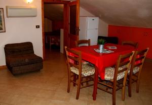a red dining room table with chairs and a red table cloth at Appartamenti Pian d'Alma in Punta Ala